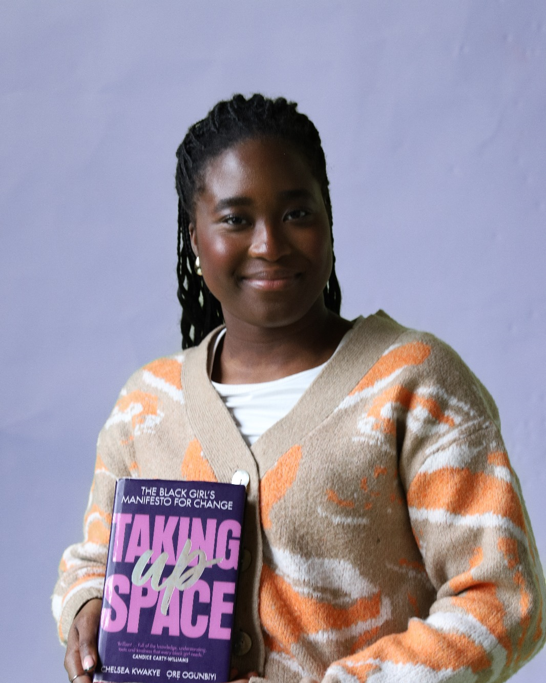 Portretfoto van Daniella met in haar hand het boek Taking Up Space van Chelsea Kwakye and Ore Ogunbiyi